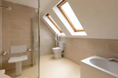 Renovated Accessible Bathroom With Walk In Shower, And Seat, And Toilet With Grab Rails