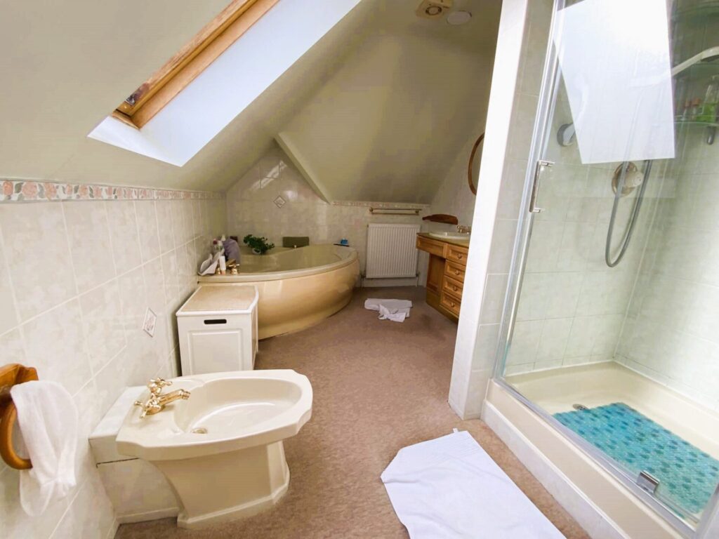 Photograph of large bathroom in the eaves of a property prior to its accessible adaptation