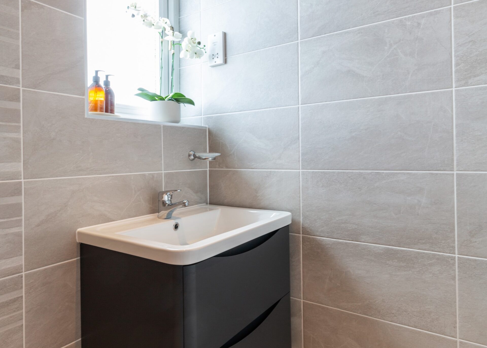 images of adapting a standard bathroom to an accessible wet room. After install vanity - close