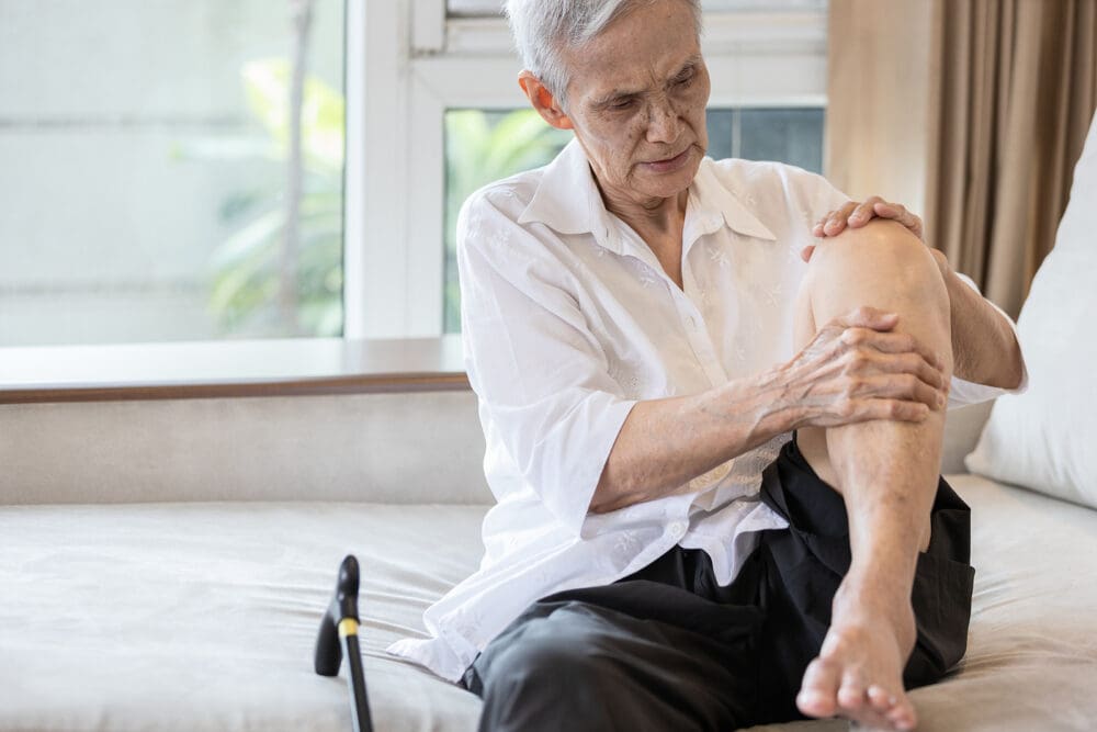 Exhausted Asian Senior Woman Hold Her Knee Suffering From Pain