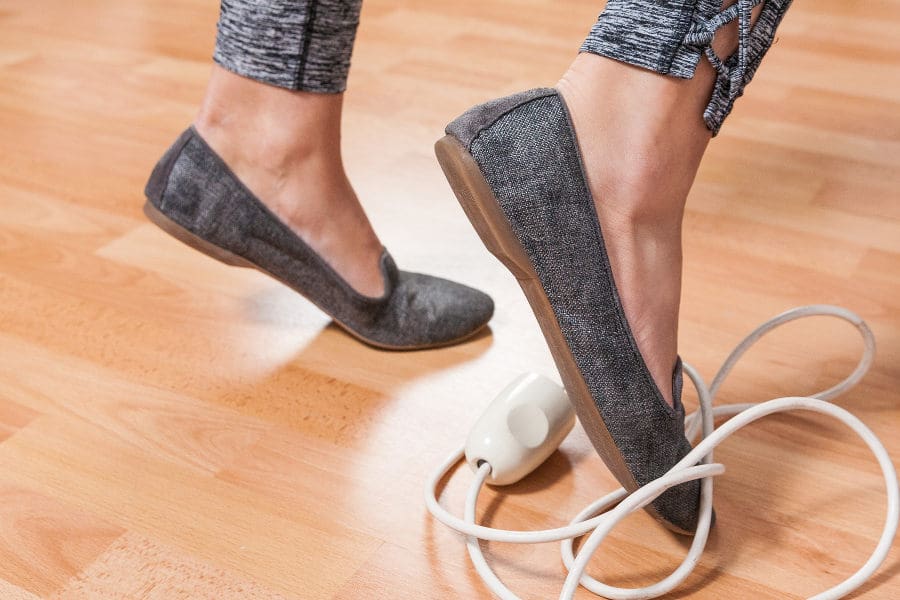 womens feet tripping over electrical cord