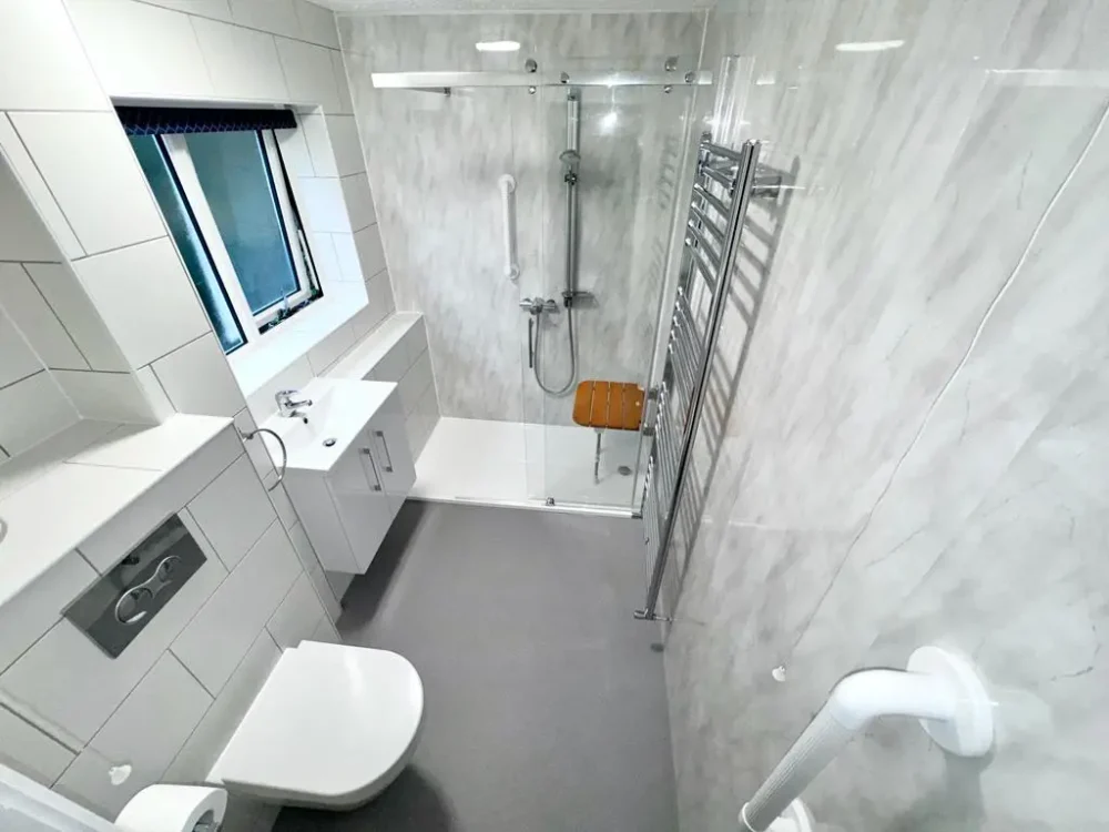 Mr And Mrs H's Bathroom After Renovation A Modern, White And Silver Design With Non Slip Floor, Gloss Walls, Walk In Shower With Grab Rails And Shower Seat And New Toilet With Grab Rails