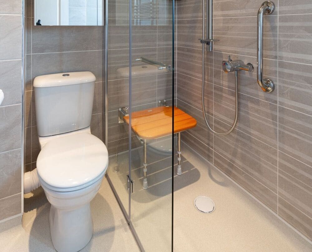 Mr And Mrs S's Bathroom After Renovation Wet Room Style Bathroom With Shower, Shower Seat, Grab Rails, Toilet, Large Mirror And Stylish Brown Striped Tiling