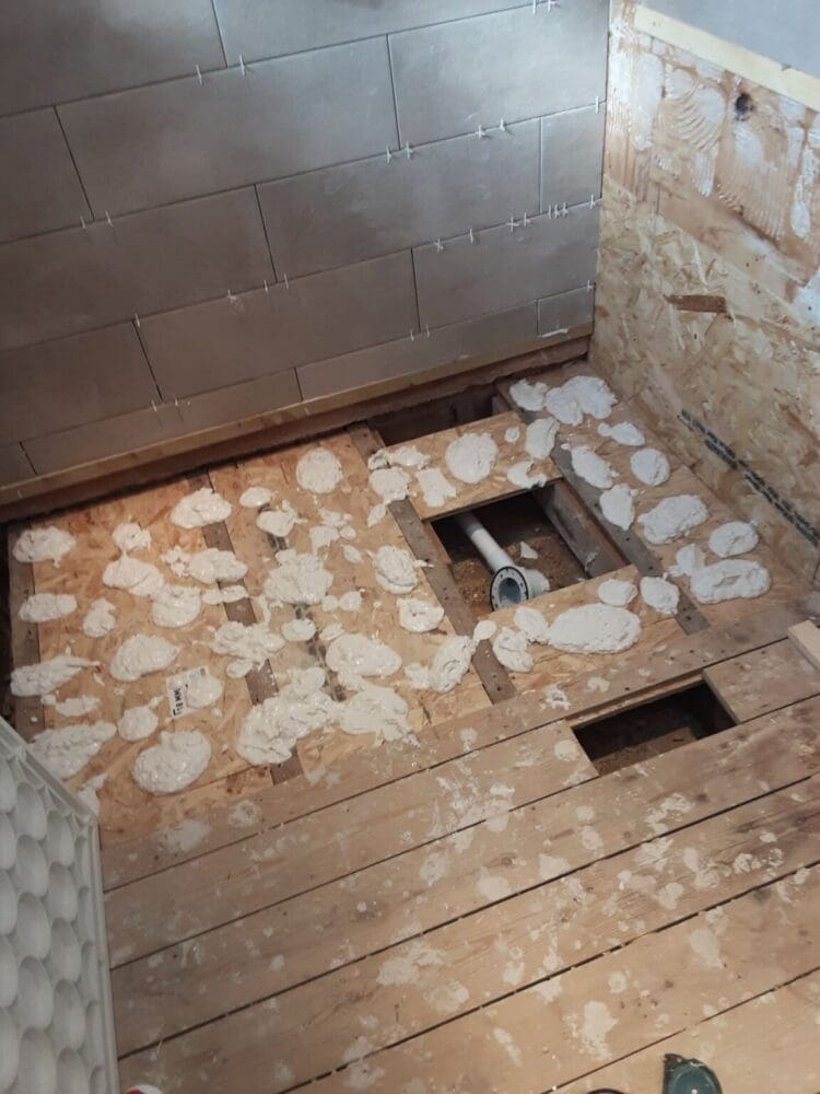 Mr And Mrs' Wells Bathrom Before Renovation Empty Room With No Flooring, Wooden Slats And Block Walls