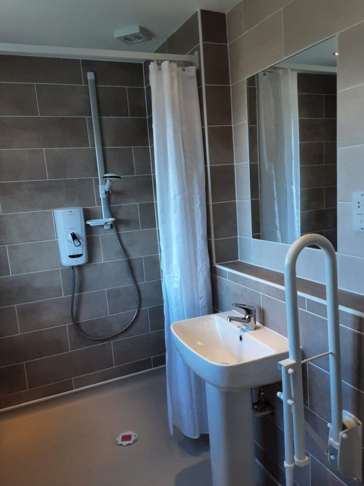 Mrs And Mrs Well's Bathroom After Renovation Low Level Access Shower And Sink With Grab Rails