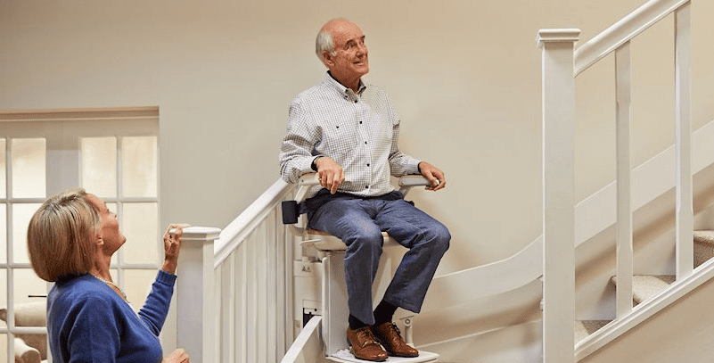 Elderly Man Going Up Stairs On Stair Lift