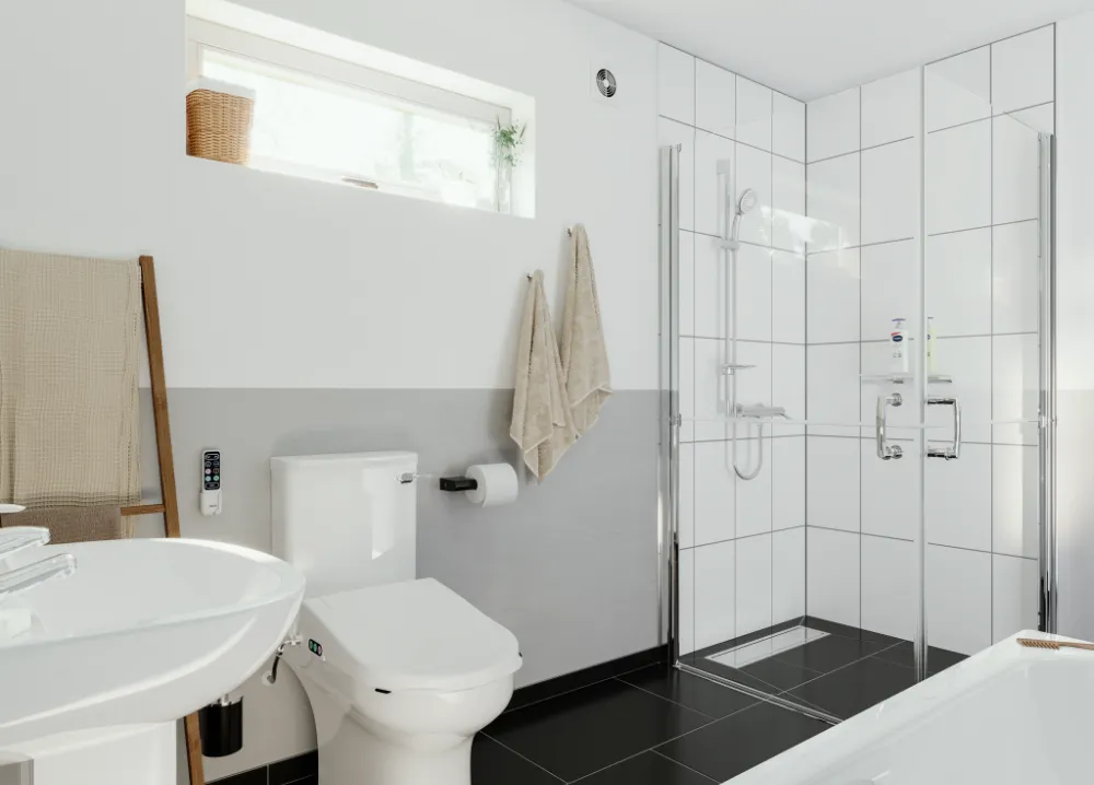 Neutral Coloured Wet Room Bathroom With White Tiles, Grey And White Walls And White Floor, Walk In Accessible Shower, Toilet And Sink